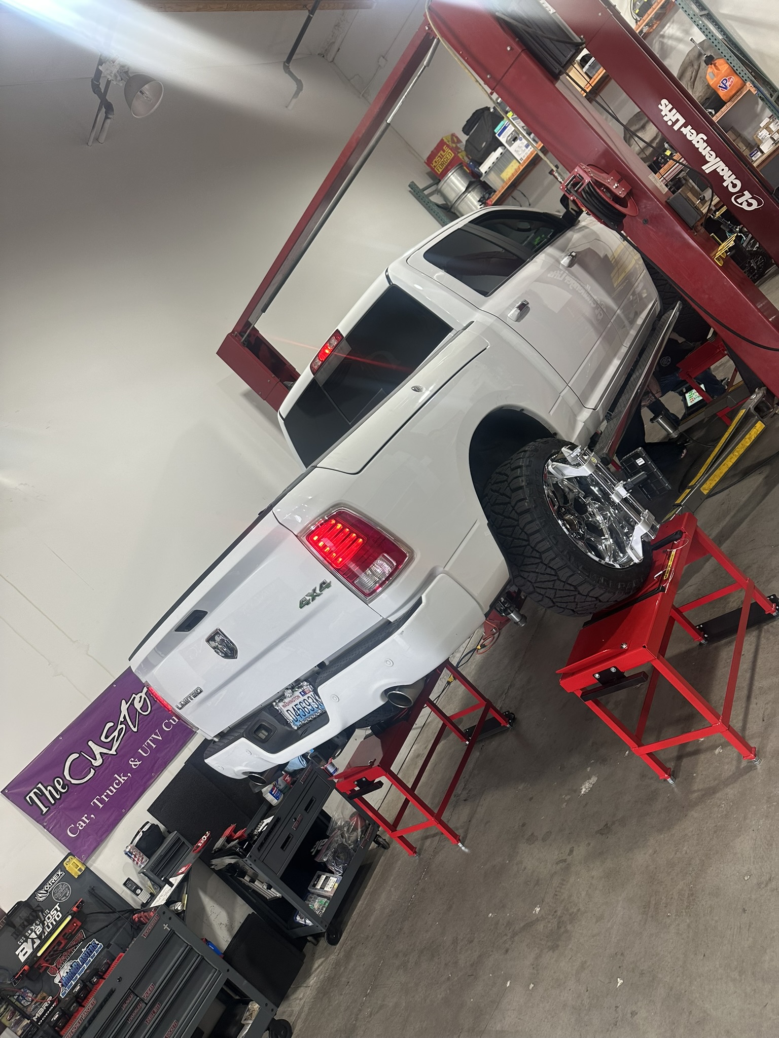 White Ram 1500 on the wheel alignment rack after suspension, wheel and tire installation