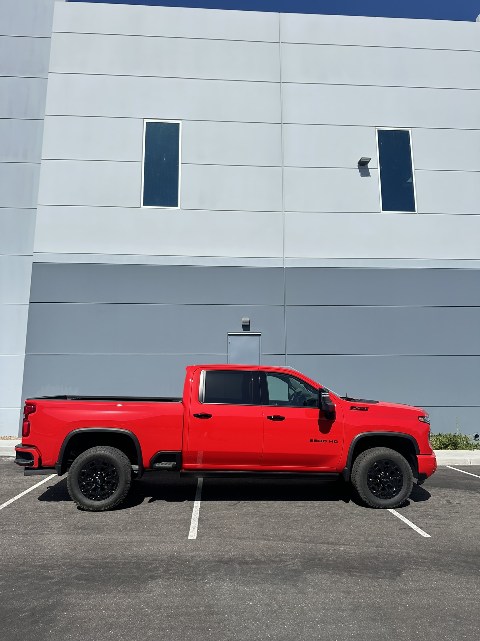 Red Chevrolet Silverado 2500HD side profile before suspension and wheel upgrades