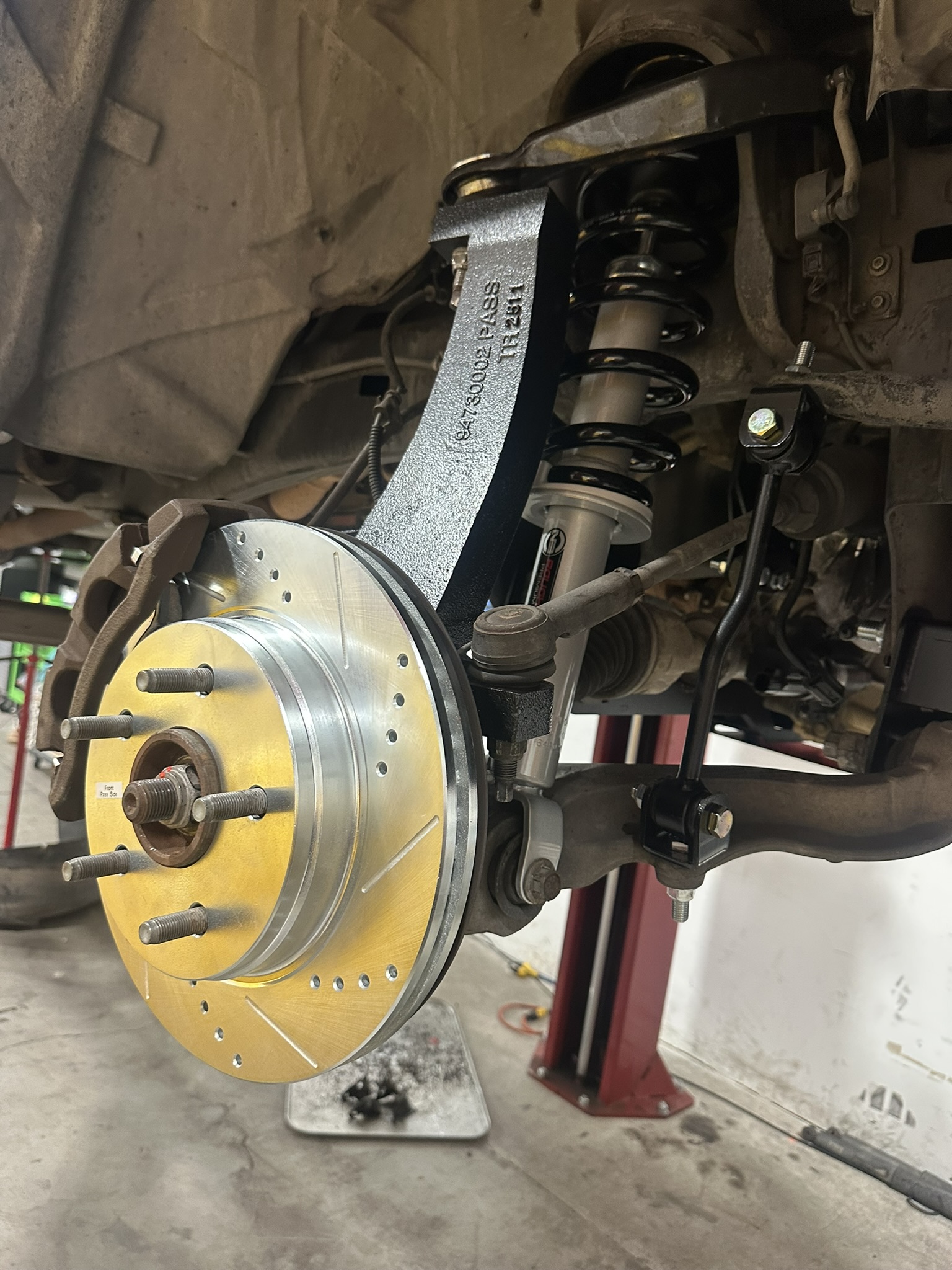 Front PowerStop brake rotor beside Rough Country suspension components