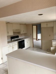 Original kitchen with white cabinets, an older stove, and laminate countertops
