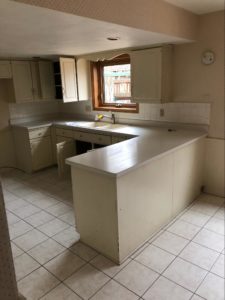 Kitchen before renovation with laminate counters and a U-shaped peninsula