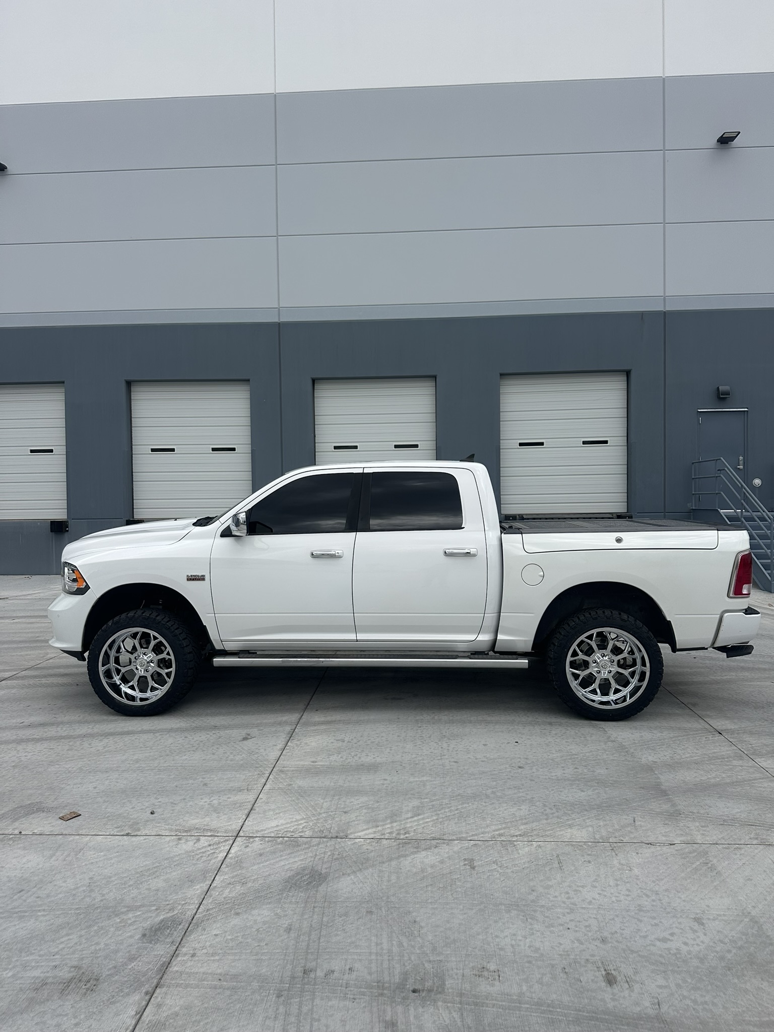 Finished white Ram 1500 side profile with chrome wheels outside The Custom Shop