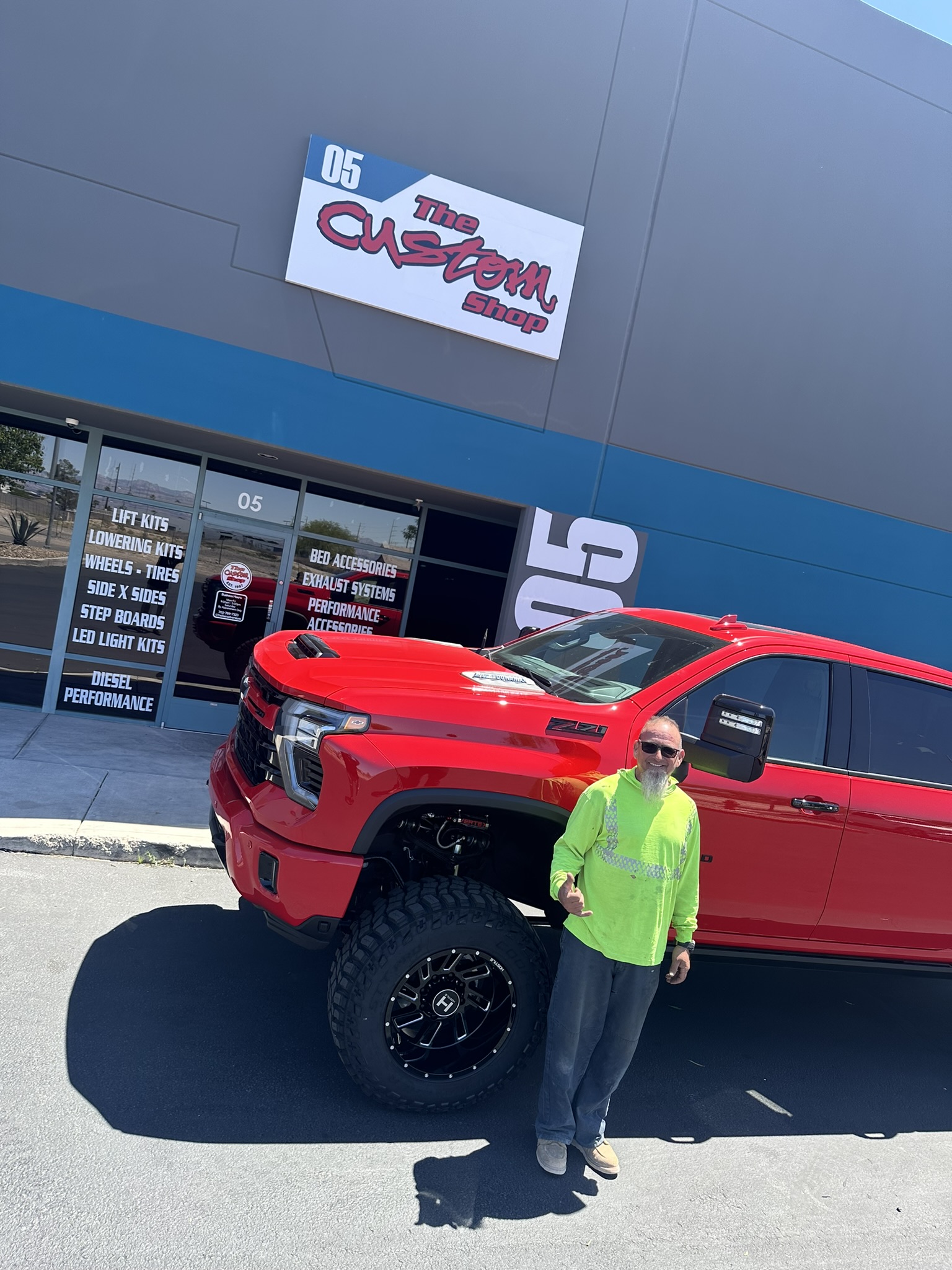 A man standing beside the completed Silverado outside The Custom Shop
