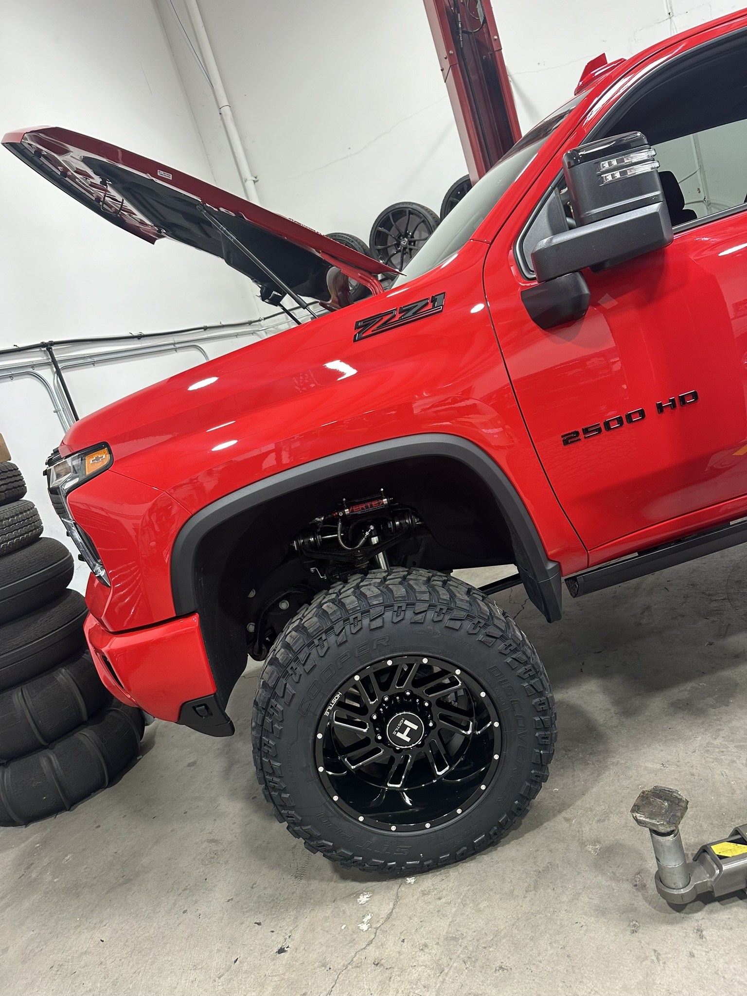 Front Hostile wheel and Vertex suspension installed on the red Silverado