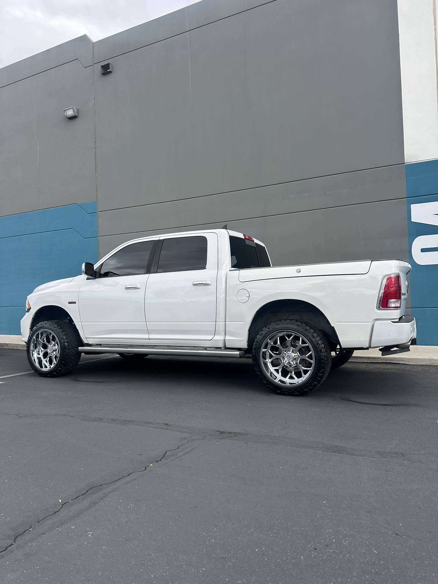 Rear three-quarter view of the finished Ram 1500 with a 4-inch lift and chrome wheels